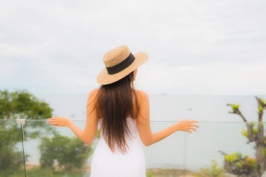 Portriat güzel genç Asyalı kadın deniz manzaralı balkonda mutlu bir gülümseme