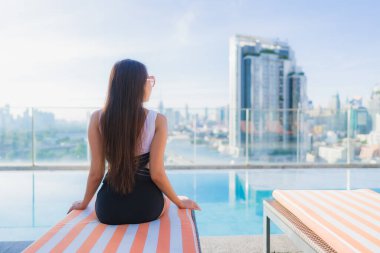 Güzel bir Asyalı kadının portresi tatil gezilerinde yüzme havuzunda rahatlar.