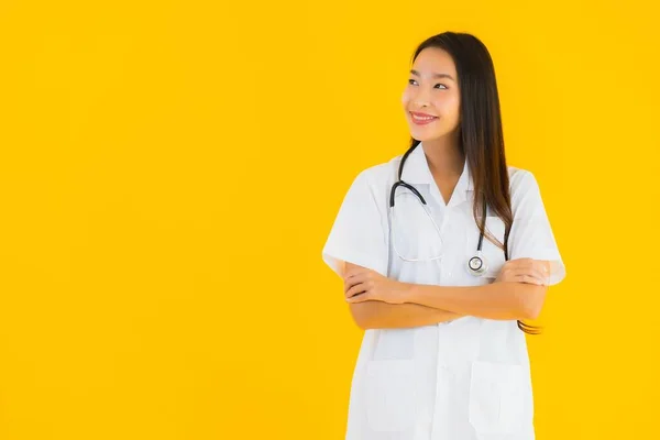 美丽的年轻亚洲医生女人笑着快乐地在医院和诊所工作 背景是黄色孤立的 — 图库照片