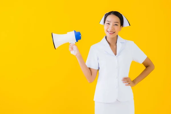 带扩音器的美丽的年轻亚洲妇女泰伊护士形象 供临床和医院在黄色隔离背景下进行交流 — 图库照片