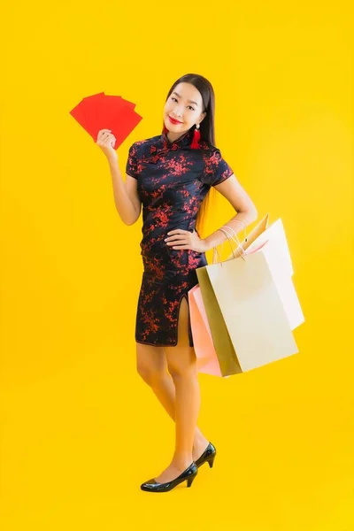 아름다운 아시아 여성의 초상화에는 쇼핑백 스마트폰 노랗게 고립된 배경을 가지고 — 스톡 사진