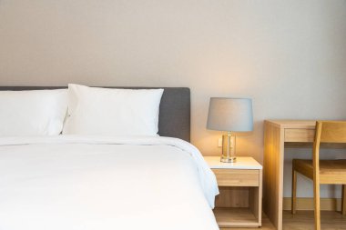 Yatak odasının iç dekorasyonuna beyaz yastık ve battaniye. İçinde lamba var.