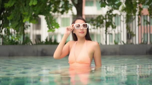 肖像画美しい若いアジアの女性幸せな笑顔休暇旅行のためのリゾートホテルで屋外スイミングプールをリラックス — ストック動画