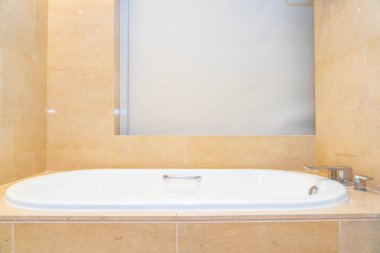 Banyonun içi musluk dekorasyonuyla dolu boş bir banyo küveti.