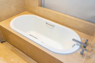 Banyonun içi musluk dekorasyonuyla dolu boş bir banyo küveti.