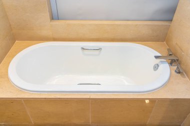 Banyonun içi musluk dekorasyonuyla dolu boş bir banyo küveti.