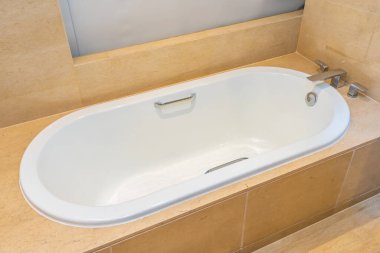 Banyonun içi musluk dekorasyonuyla dolu boş bir banyo küveti.