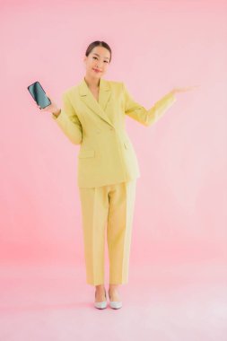 Güzel Asyalı iş kadını portresi. Arka planda kahve fincanı ve akıllı cep telefonu kullanıyor.