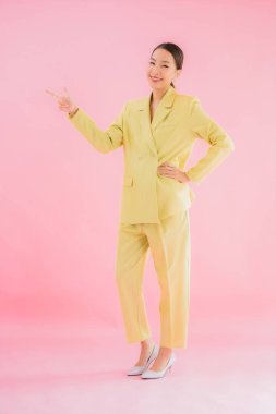 Portre güzel Asyalı genç iş kadını pembe arka planda gülümsüyor