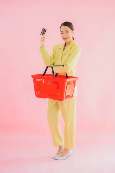 ポートレート美しい若いですアジアの女性とともにスーパーマーケットからの食料品バスケット色の背景 — ストック写真