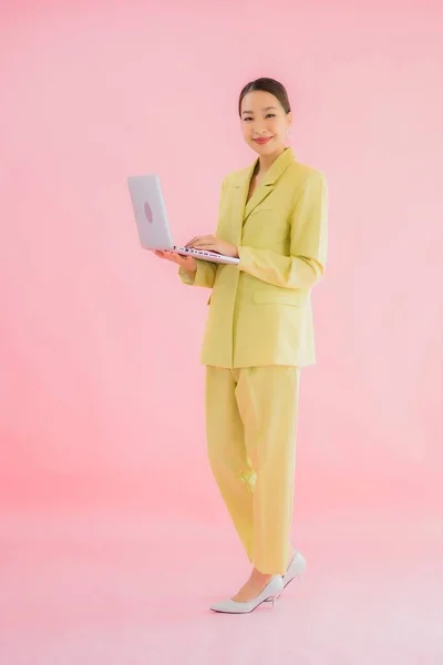 形象漂亮的年轻亚洲女商人在彩色背景下使用电脑笔记本电脑 — 图库照片