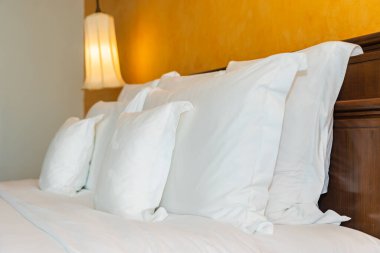 Yatak odasının iç dekorasyonunda beyaz rahat yastık.