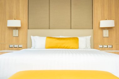 Yatağın üstünde yastık, odanın içinde battaniye süslemesi var.