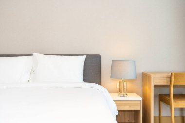 Yatak odasının iç dekorasyonuna beyaz yastık ve battaniye. İçinde lamba var.