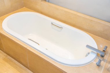 Banyonun içi musluk dekorasyonuyla dolu boş bir banyo küveti.