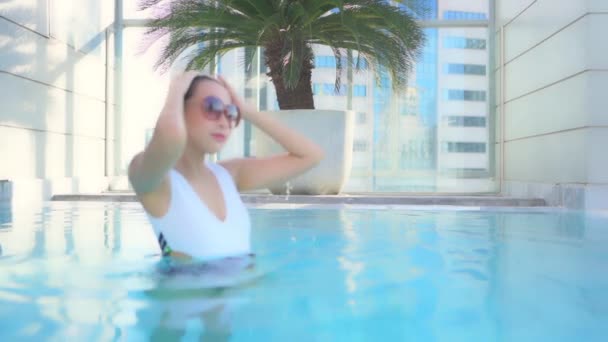 여가를 즐기기 리조트 수영장에서 휴식을 취하는 아름답고 이시아 여성의 — 비디오