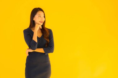 İzole edilmiş sarı arka planda hareketli güzel Asyalı kadın portresi.