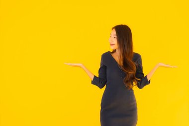 İzole edilmiş sarı arka planda hareketli güzel Asyalı kadın portresi.