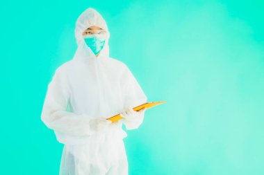 Güzel, genç Asyalı doktor kadın koronavirüsten korunmak için ppe ya da kişisel koruyucu ekipman takıyor ya da mavi izole arka planda beyaz kartı olan 19. bölgede yaşıyor.