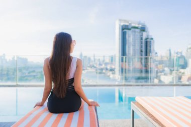 Güzel bir Asyalı kadının portresi tatil gezilerinde yüzme havuzunda rahatlar.