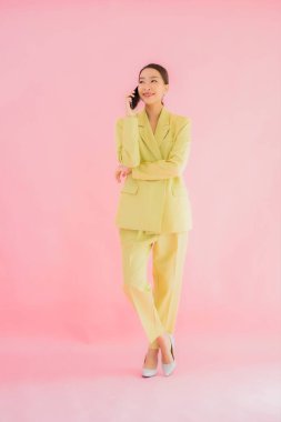 Güzel Asyalı iş kadını portresi. Arka planda kahve fincanı ve akıllı cep telefonu kullanıyor.