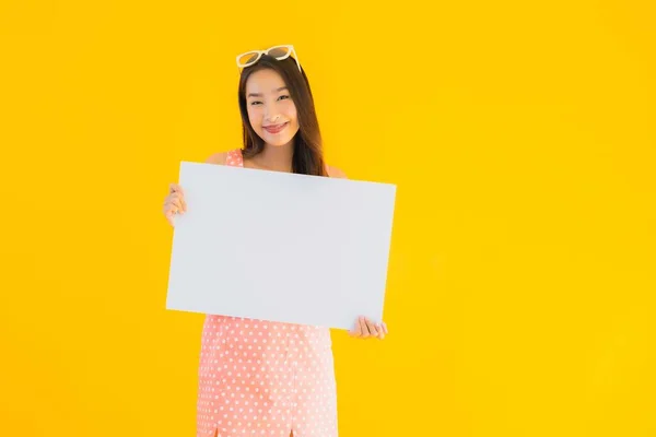 肖像美しい若いアジアの女性ショー空のホワイトBillboardのためにテキストとコピースペース上の黄色隔離された背景 — ストック写真