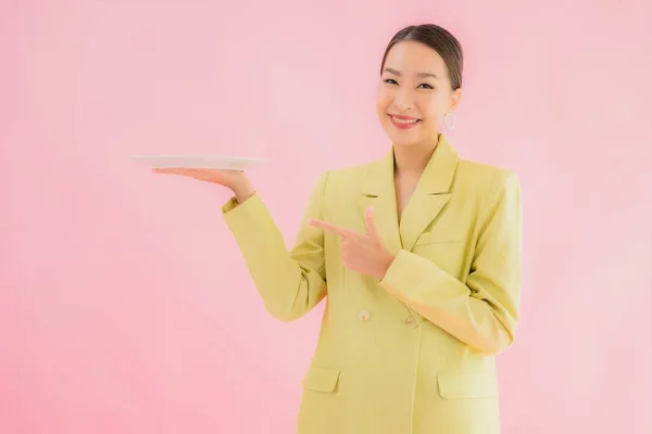 色の背景に皿やプレートと美しい若いアジアのビジネス女性の肖像画 — ストック写真