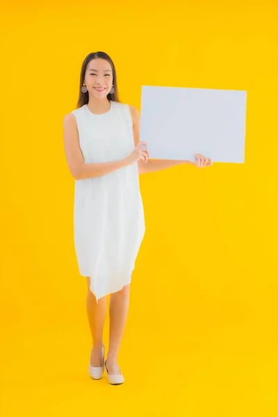 形象美丽的年轻亚洲女人 白色的空广告牌 孤立的黄色背景 — 图库照片
