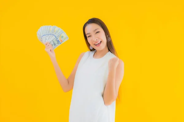 노란색외진 배경에 현금을 아름다운 아시아 여자의 — 스톡 사진