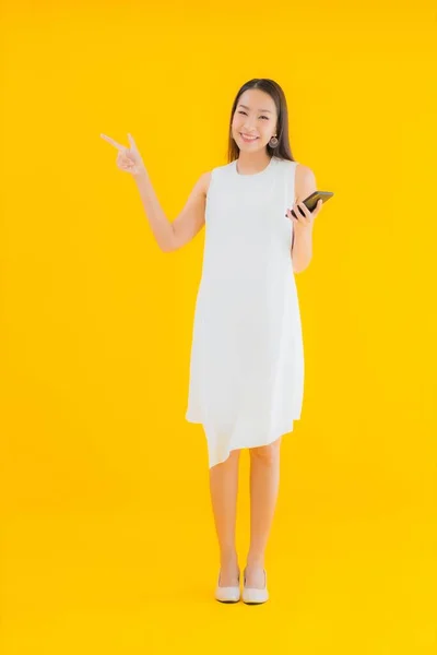 Portré Gyönyörű Fiatal Ázsiai Okos Mobiltelefon Sárga Elszigetelt Háttér — Stock Fotó