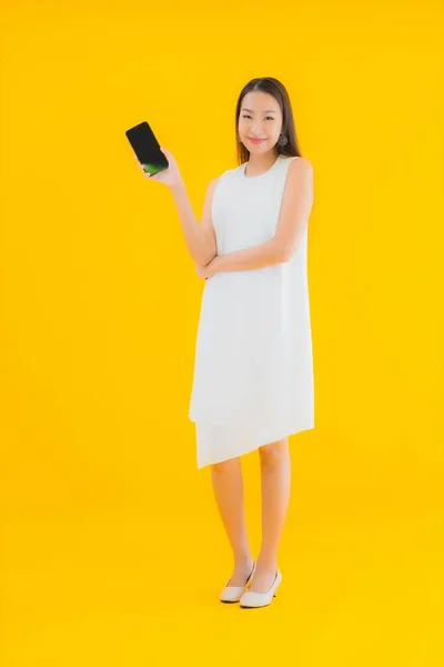 Portré Gyönyörű Fiatal Ázsiai Okos Mobiltelefon Sárga Elszigetelt Háttér — Stock Fotó
