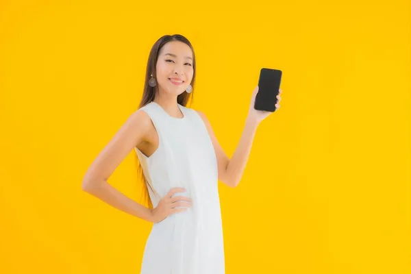 Portret Pięknej Młodej Azjatyckiej Kobiety Inteligentnym Telefonem Komórkowym Żółtym Odizolowanym — Zdjęcie stockowe