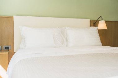 Yatak odasının iç dekorasyonunda beyaz rahat yastık.