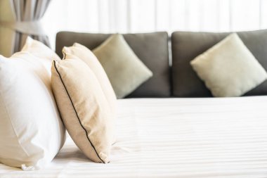 Otel odasındaki yatak odasının iç dekorasyonunda beyaz rahat yastık.