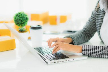Güzel Asyalı iş kadını portresi evden bilgisayarlı cep telefonuyla karton kutuyla çevrimiçi alışveriş için hazır bekliyor.