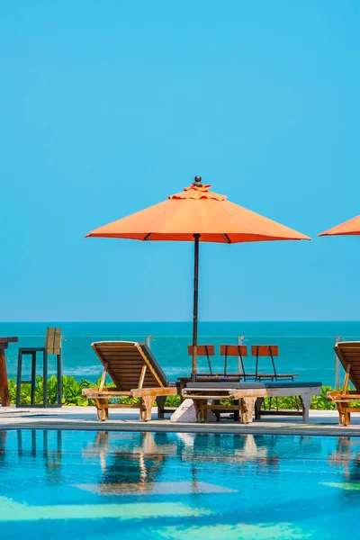 Şemsiye ve sandalye açık havuz etrafında. Tatil tatili için otel odasında deniz yok.