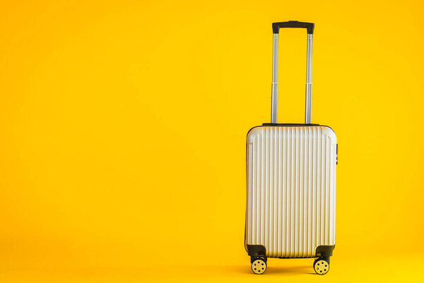 Gray color luggage or baggage bag use for transportation travel and leisure on yellow isolated background