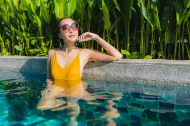 Güzel bir Asyalı kadın portresi. Rahatlayın. Keyifli bir tatil için oteldeki yüzme havuzunda mutlu bir gülümseme.