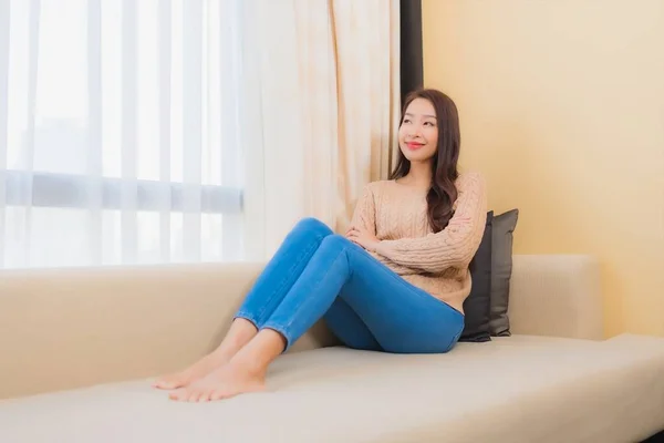 ポートレート美しい若いアジアの女性リラックス笑顔上のソファ装飾室内の幸せ — ストック写真