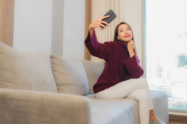 Güzel Bir Asyalı Kadın Oturma Odasındaki Koltukta Akıllı Cep Telefonu — Stok fotoğraf