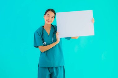 Fotokopi için boş kâğıt tahtası olan güzel Asyalı genç doktor kadın hastane ve klinikteki sağlık hizmetleri konseptinde mavi izole edilmiş arka plan.