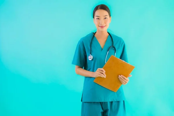 Portrait beautiful young asian doctor woman with empty paper board for copy space on blue isolated background - Healthcare in hospital and clinic concept