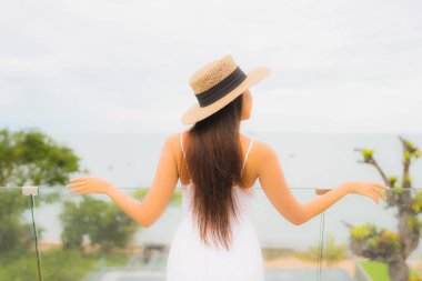 Portriat güzel genç Asyalı kadın deniz manzaralı balkonda mutlu bir gülümseme