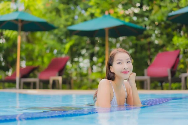 아름다운 여성이 휴가를 보내기 리조트 수영장에서 느긋하게 미소짓는 여가를 즐긴다 — 스톡 사진