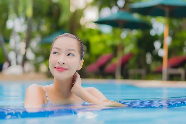 아름다운 여성이 휴가를 보내기 리조트 수영장에서 느긋하게 미소짓는 여가를 즐긴다 — 스톡 사진