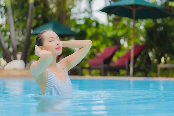 美しい若いアジアの女性は休日の休暇のためのホテルリゾートで屋外スイミングプールの周りにリラックスした笑顔のレジャーをお楽しみください — ストック写真