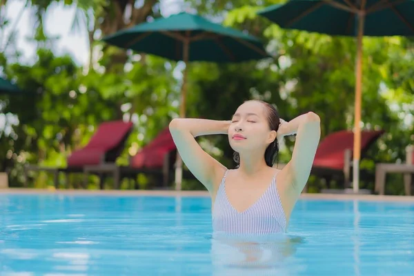 美しい若いアジアの女性は休日の休暇のためのホテルリゾートで屋外スイミングプールの周りにリラックスした笑顔のレジャーをお楽しみください — ストック写真