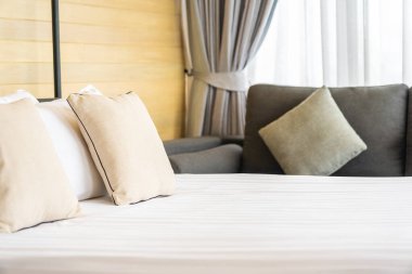 Otel odasındaki yatak odasının iç dekorasyonunda beyaz rahat yastık.