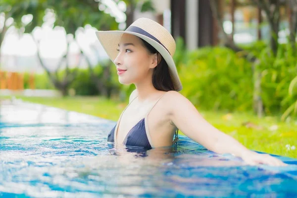 ポートレート美しい若いアジアの女性は レジャー休暇にホテルのリゾートで屋外スイミングプールの周りの笑顔をお楽しみください — ストック写真