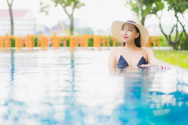 ポートレート美しい若いアジアの女性は レジャー休暇にホテルのリゾートで屋外スイミングプールの周りの笑顔をお楽しみください — ストック写真